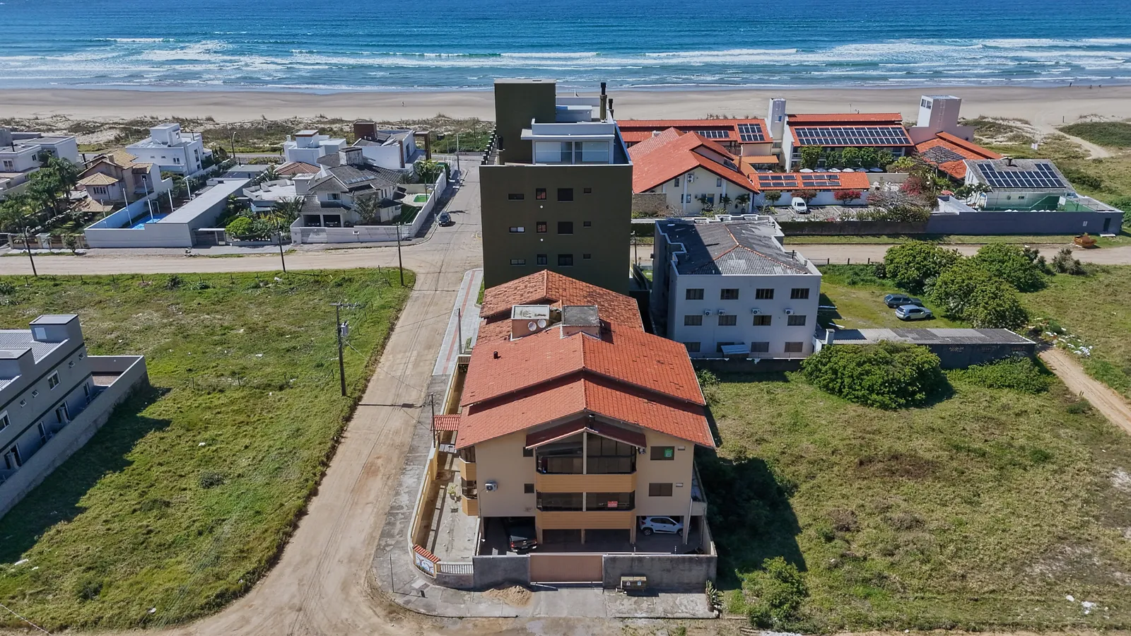 Vista aérea de cima do prédio, com as ruas ao redor e a praia.
